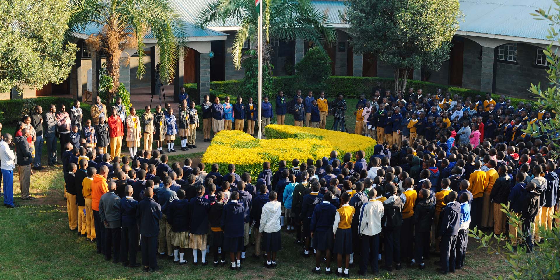"Sun and Shield" students in a parade being addressed.